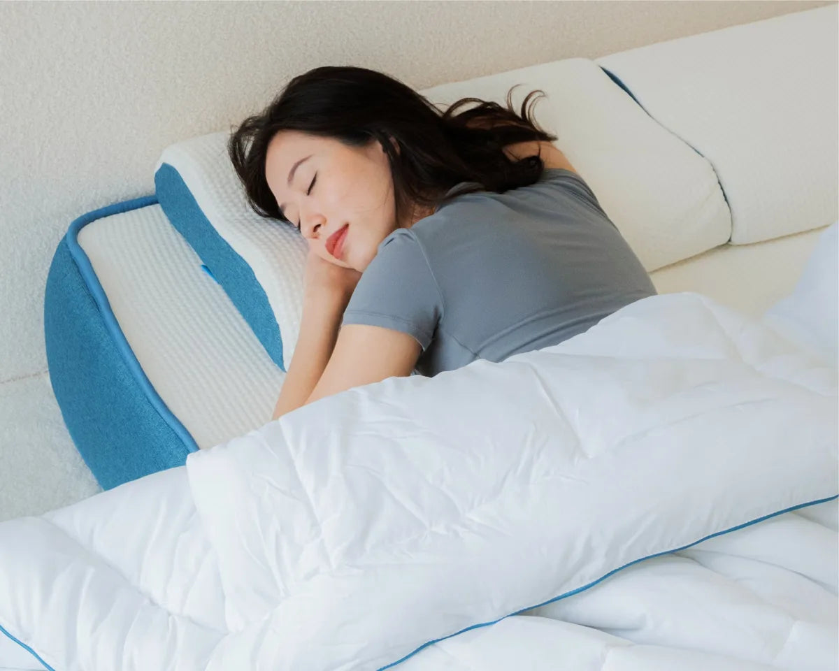 A woman lying on a Joey mattress with blue bedding